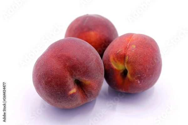 Fototapeta Three ripe red peaches close-up isolated on a white background
