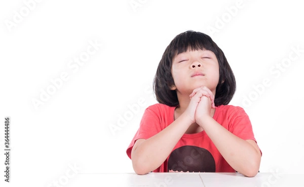 Obraz kid is praying on white background, hands folded in prayer
