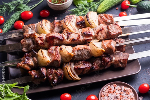 Fototapeta Fresh, home-cooked on the grill fire meat beef shish kebab with vegetables and spices, with barbecue sauce and ketchup, on a dark background. Shish kebabs - grilled meat and vegetables
Lamb Skewers