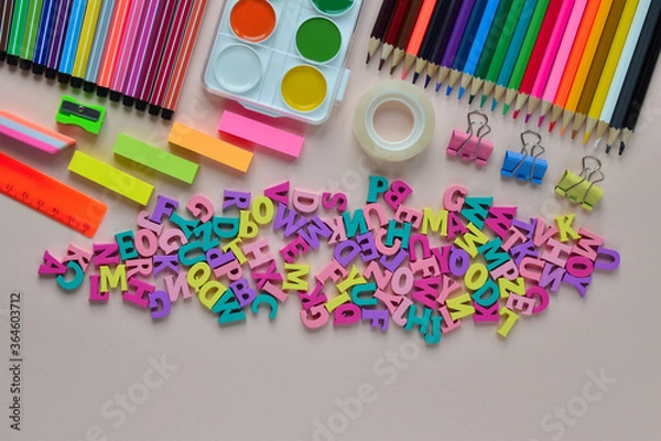 Fototapeta Banner back to school. Stationery and multicolored letters with place for text.