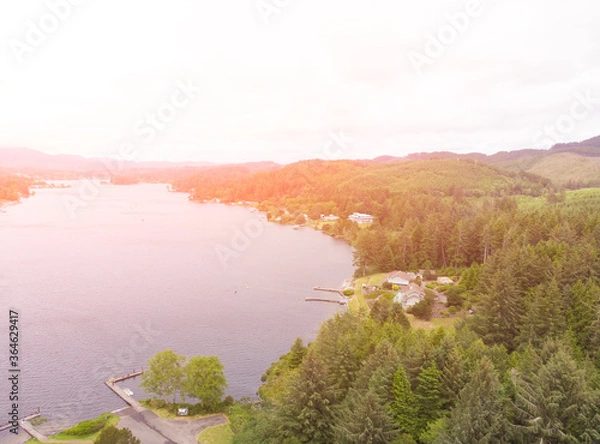 Fototapeta Shore of a bay or river or lake, against the background of the forest, aerial view at sunset