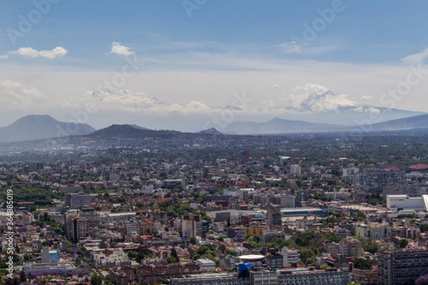 Fototapeta aerial view of typical Mexican living and working area in the southern part of town, with volcanoes in the back