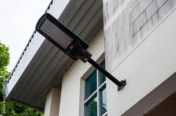 Fototapeta Solar lamps attached to the side of the building for illumination at night.Solar lamp next to the building