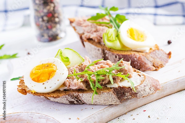 Fototapeta Toasts with tuna. Italian bruschetta sandwiches with canned tuna, egg and cucumber.