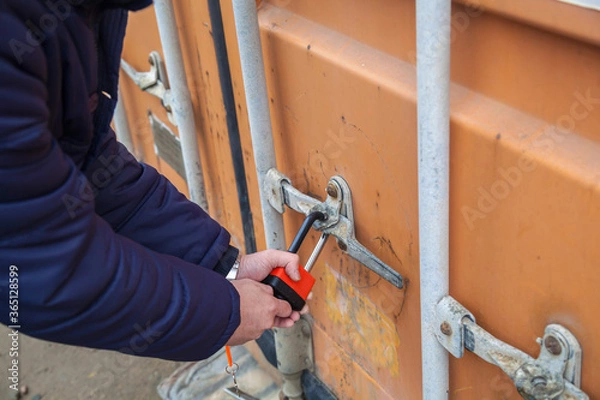 Obraz The man opens the lock. Man closes the lock. Container.