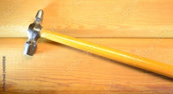 Fototapeta small hammer with a wooden handle on a background of wooden planks