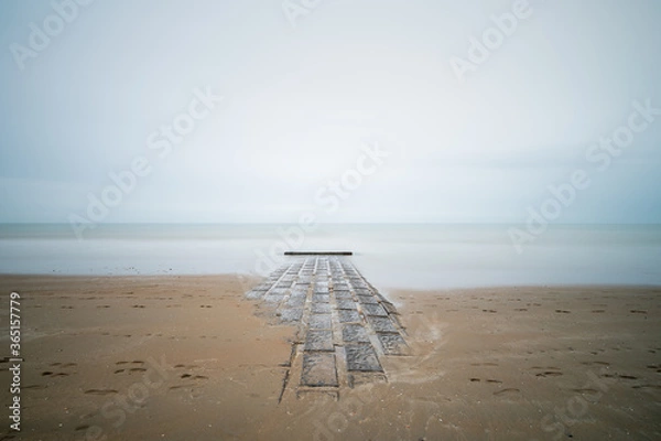 Obraz A breakwater enters a misty sea in the North Sea.