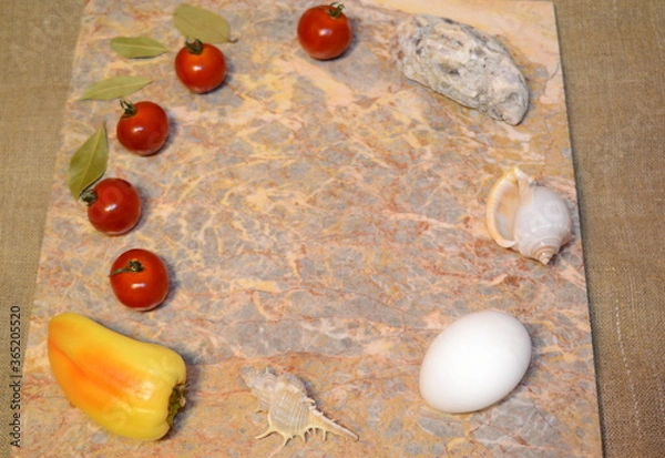 Fototapeta vegetables, chicken eggs and seashells on a marble surface with free space: cherry tomatoes, bell peppers, garlic and bay leaves