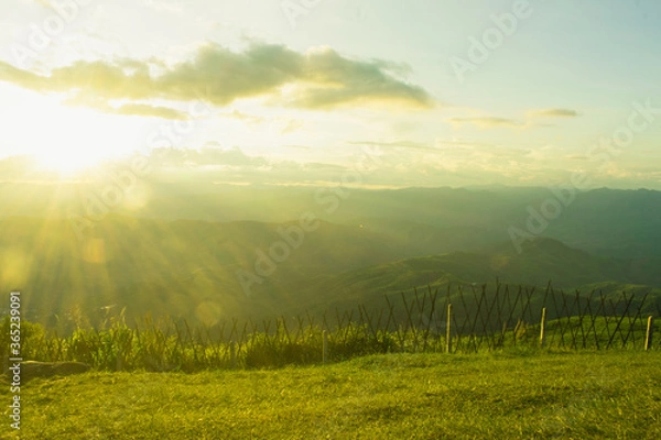 Obraz Sunset and mountains interspersed with green grass