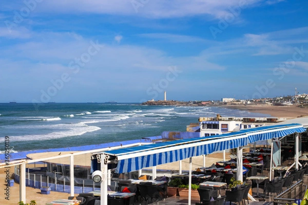 Obraz Empty restaurant on Cornish Boulevard with views of the Atlantic ocean and El Hank lighthouse, Casablanca, Morocco