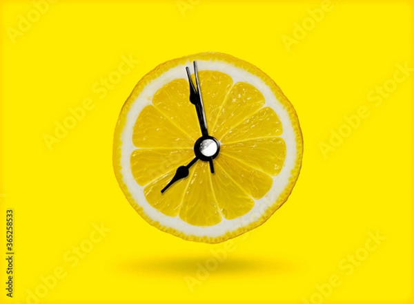 Obraz Lemon and the clock are the idea of ​​a healthy breakfast or a bright morning awakening.