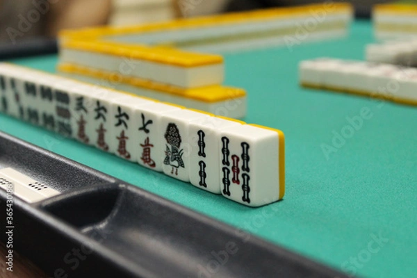 Obraz Bones for mahjong are on a green table, the back and side plan are blurred. Tabletop traditional Asian game. Selective focus.