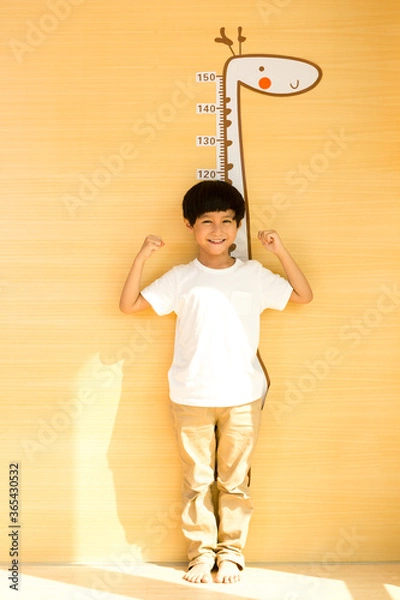 Fototapeta Little boy measuring his height at home
