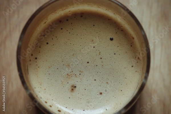 Fototapeta Close-up of a glass of coffee with milk, with white foam.