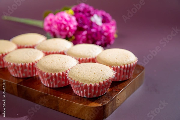 Fototapeta Ancient egg cakes in paper cup with purple background