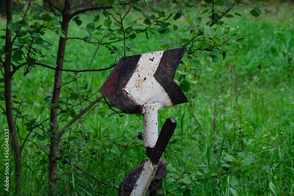 Fototapeta Arrow on the railroad. Railway arrow on an old road in the grass