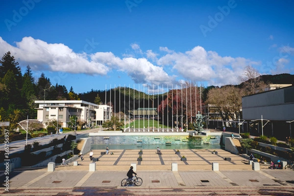 Obraz People walking and biking at the central square of the campus of the University of Concepción in a sunny day