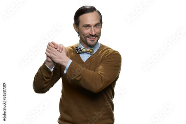 Fototapeta Smiling mature man in sweater is doing a support gesture. Happy european man squeezes his hands. Attractive casual-dressed man isolated on white background.