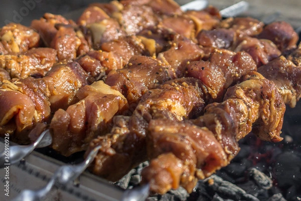 Fototapeta Shish kebab on skewers. Fry meat on coals. Picnic food. Grilled cue ball. BBQ meat in spices and marinade. Juicy cuts of meat in the smoke of the fire.
