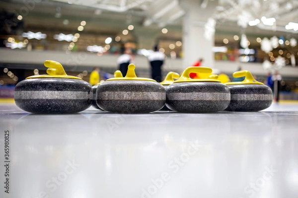 Fototapeta The curling stone or rock is made of granite with yellow handles lie