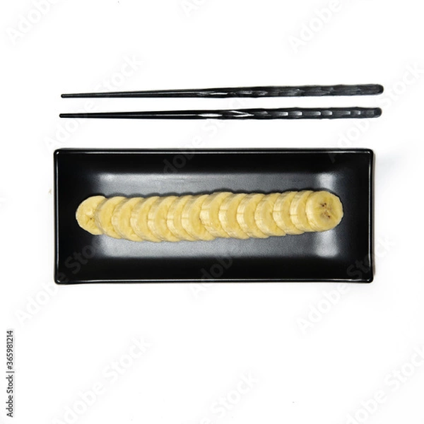 Obraz black plate and chopsticks with a banana