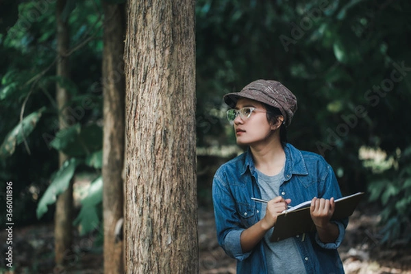 Fototapeta Botanists are looking at the bark of trees to make notes for researches on the environment. Climate change and save the earth concept.