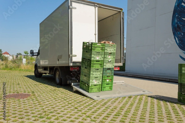 Fototapeta Unloading food crates. Delivery of goods to shops and cafes