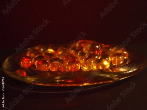 Obraz Trans-lucid cod liver oil pills under colourful light
