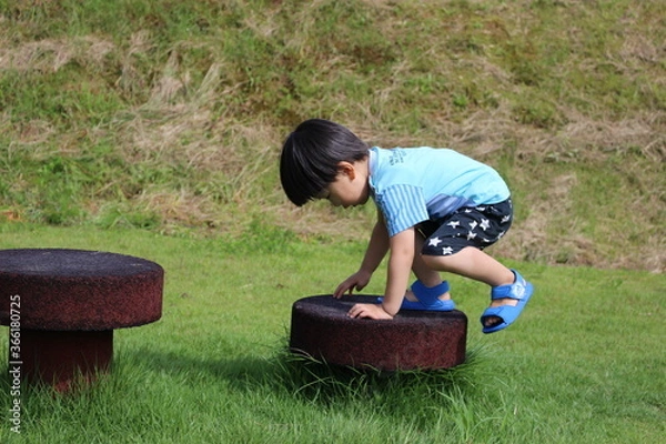 Obraz アスレチックの遊具によじ登る男児