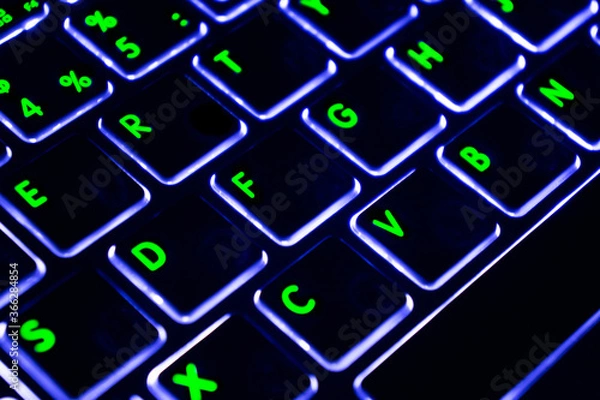 Fototapeta Close up view of a modern laptop computer keyboard key with blue buttonss. Pc computer keyboard close up