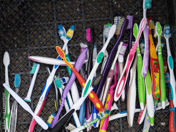 Fototapeta Used toothbrushes are collected for disposal. Separate garbage collection. Waste sorting. A lot of old toothbrushes are in the drawer.