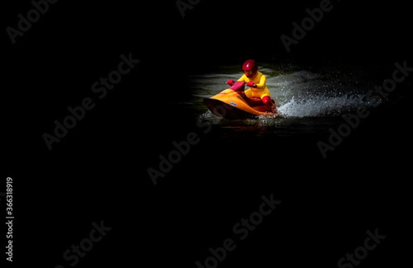 Obraz RC controlled jet ski model on lake on black background. Active summer vacation for school child.