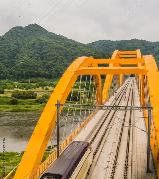 Fototapeta Top view of train crossing yellow bridge