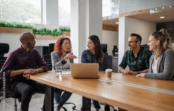 Fototapeta Diverse team of businesspeople having a meeting around a table