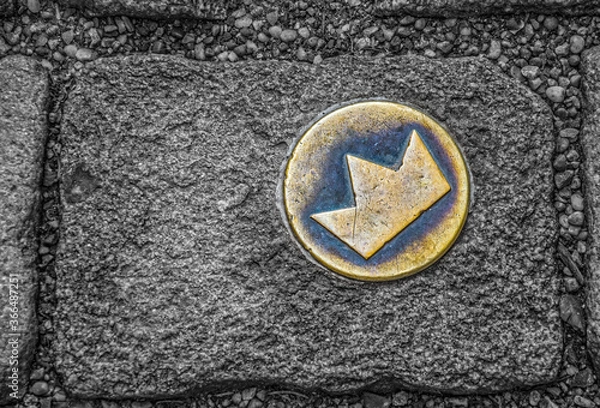 Fototapeta Top view of brass crown marker in cobblestone streets that shows location of the coronation walk, Old town, Bratislava, Slovakia