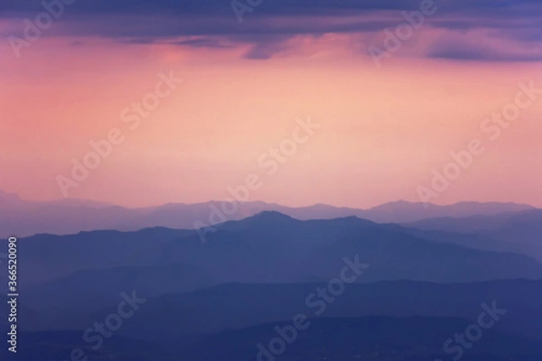 Fototapeta Silhouettes of mountains the evening light with haze in the atmosphere, perspective aerial view.