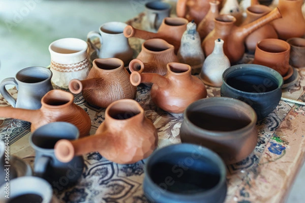 Fototapeta Clay pottery ceramics. Many different pottery standing in a potery workshop.