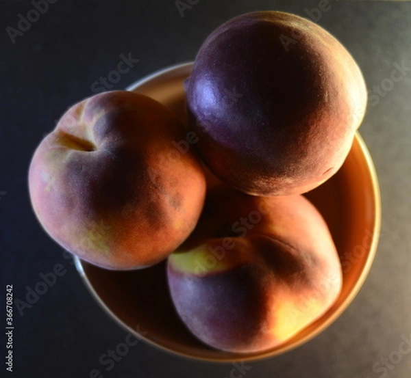 Fototapeta peaches close-up in a file on a dark background top view