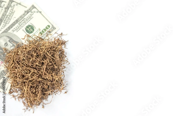 Fototapeta banknote lay under heap of tobacco on white background from overhead view with copy space. concept for tobacco trading.