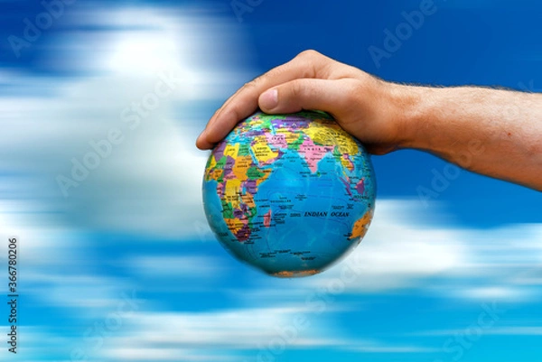 Fototapeta Conceptual symbol human hands surrounding the Earth world globe. the sky in motion