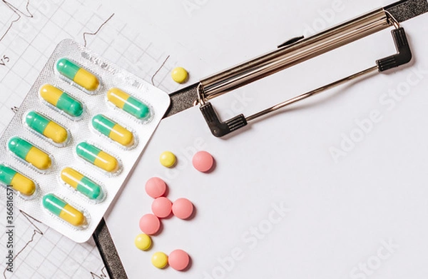 Fototapeta Pills on the table at the doctor. Medicine, treatment, illness. Medication in tablets.