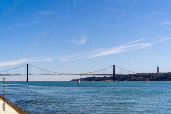 Fototapeta The 25 de Abril Bridge is a bridge connecting the city of Lisbon to the municipality of Almada on the left bank of the Tejo river, Lisbon