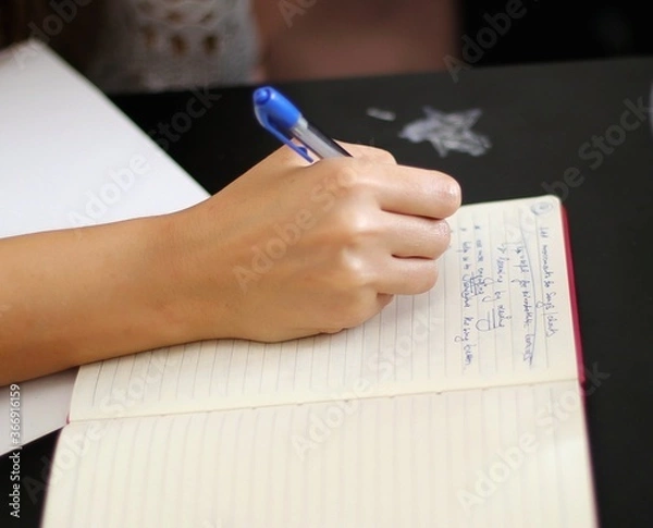 Fototapeta close up of hand writing on paper