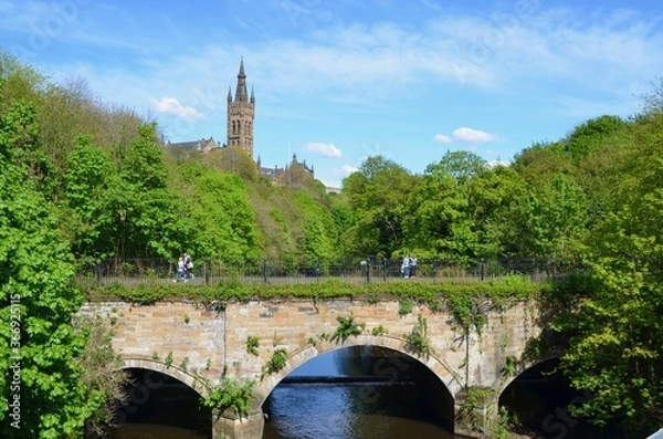 Fototapeta View of University Tower at Glasgow University from Kelvingrove Park. Arched stone bridge in foreground