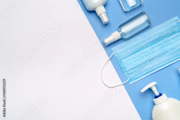 Fototapeta bottle of lotion, sanitizer or liquid soap and medical protective mask isolated on light grey background