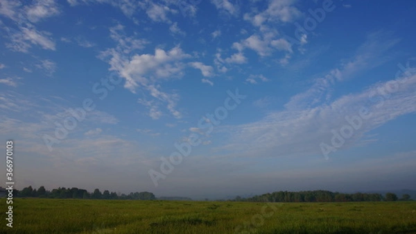 Fototapeta blue sky with clouds and a field
