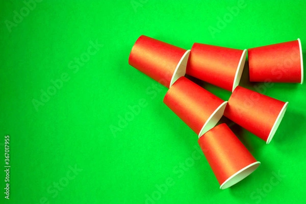 Fototapeta Paper cups on a green background. Ecological tableware. Minimalistic style. Top view.