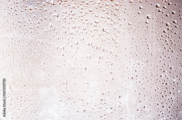 Obraz Water drops on a blurred background in close-up. Raindrops on a sunset background. Water on glass. Drops hang
