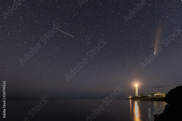 Fototapeta Panoramic HDR Landscape view of Neowise comet over white Lighthouse at night sky