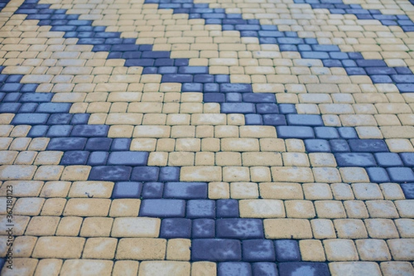 Fototapeta Nested pavers of various colors, around the grass is green, chic garden